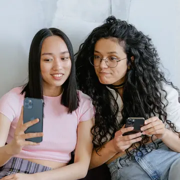 Two friends on a sofa with their phones